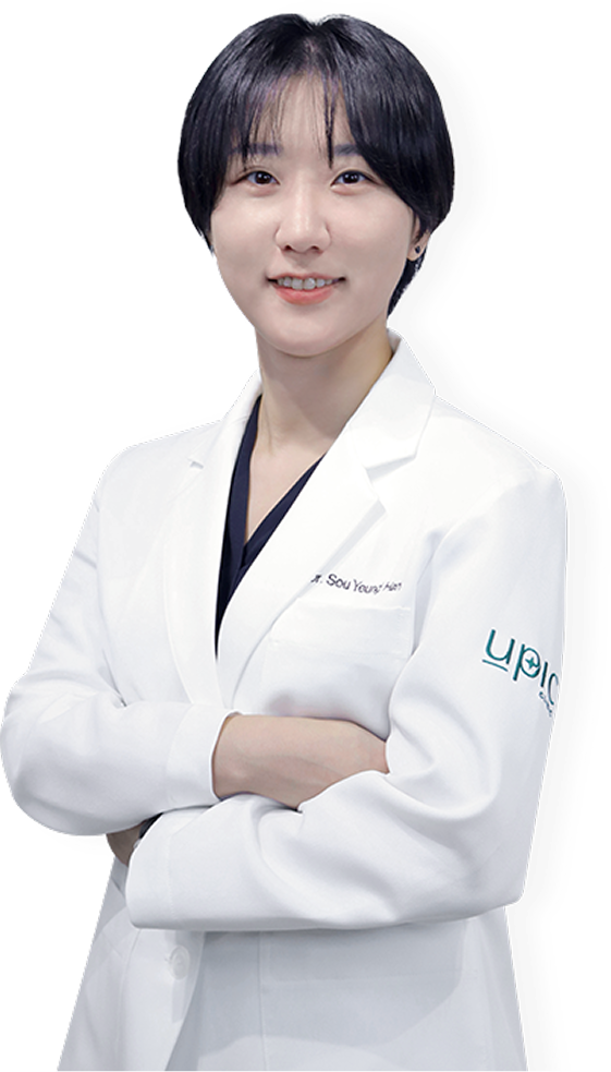 Dr. Sou Young Han, a doctor wearing a white coat, stands with arms crossed.